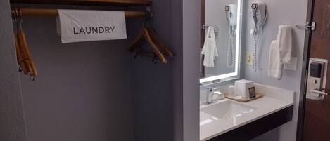 Un baño con lavamanos, espejo, toallero y un letrero que dice "LAUNDRY".
