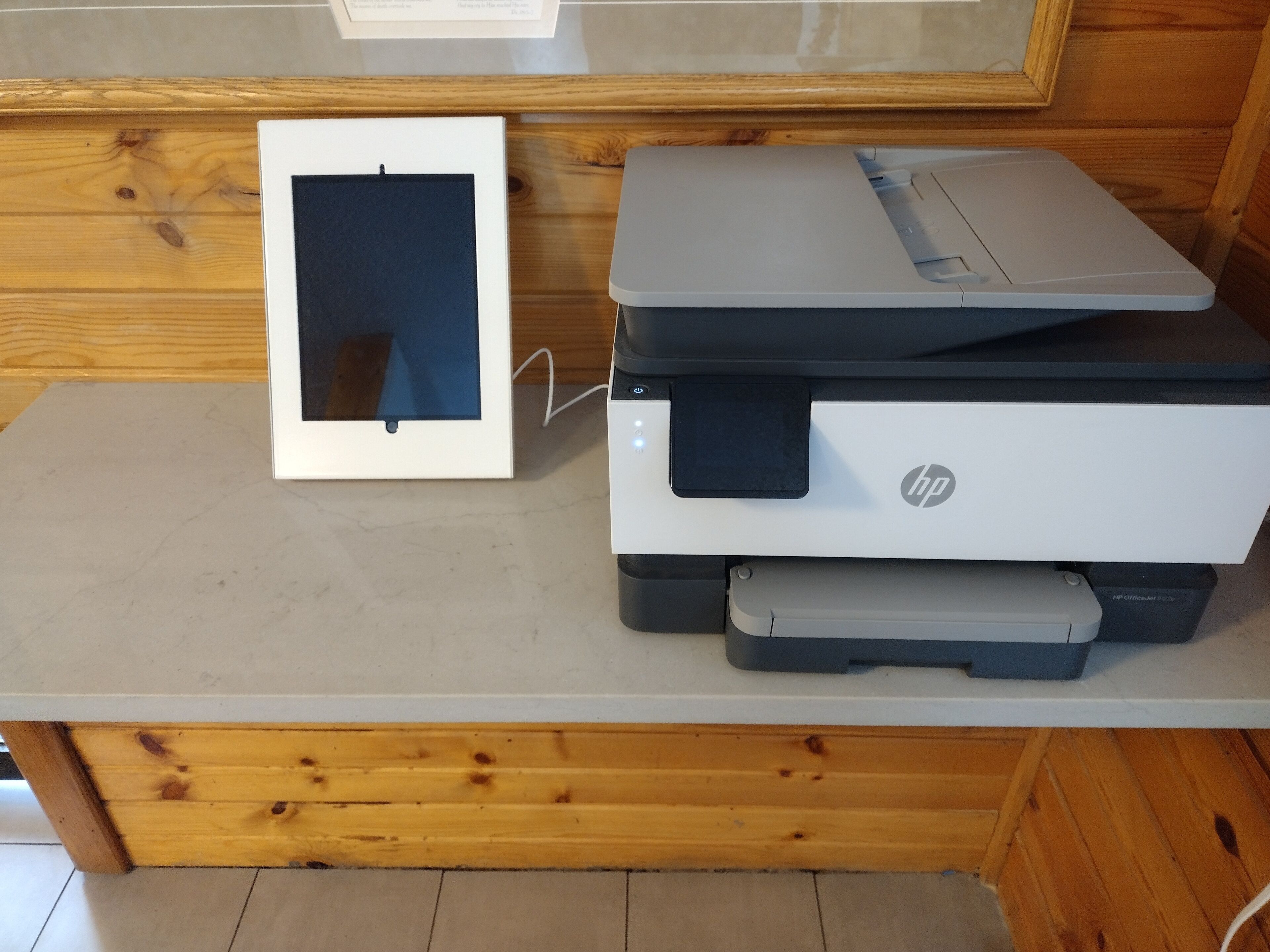 Une imprimante et un tableau encadré sur une table en bois.