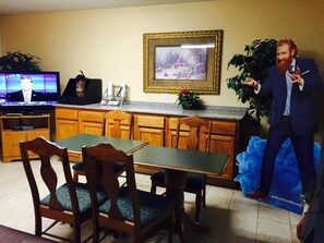 A room with a television, wooden furniture, and a framed picture on the wall.