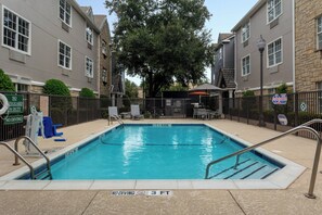 A rectangular swimming pool with a no diving sign, surrounded by a fence, and a lifeguard sign indicating no diving. - TownePlace Suites by Marriott Dallas Plano/Legacy (Plano)