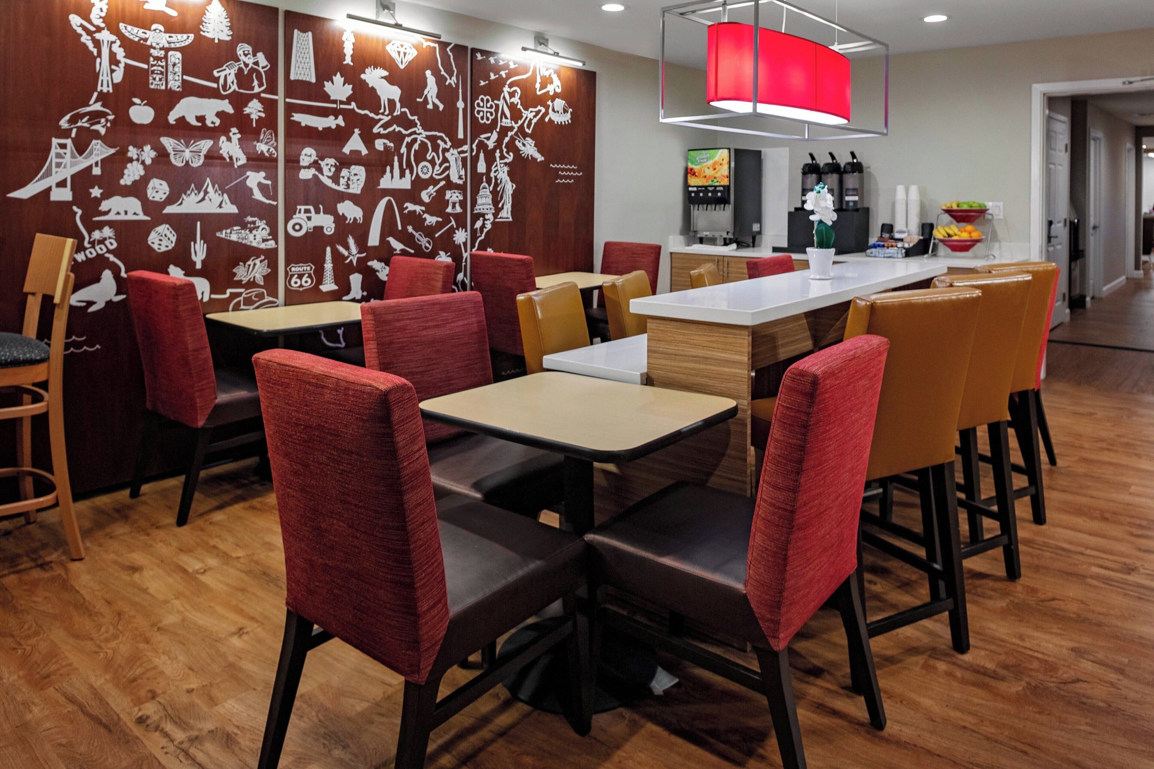Ein Restaurant mit Holzböden, rotbraunen Polsterstühlen und einem weißen Tisch.