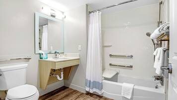 A modern bathroom with a toilet, sink, mirror, shower, and bathtub.