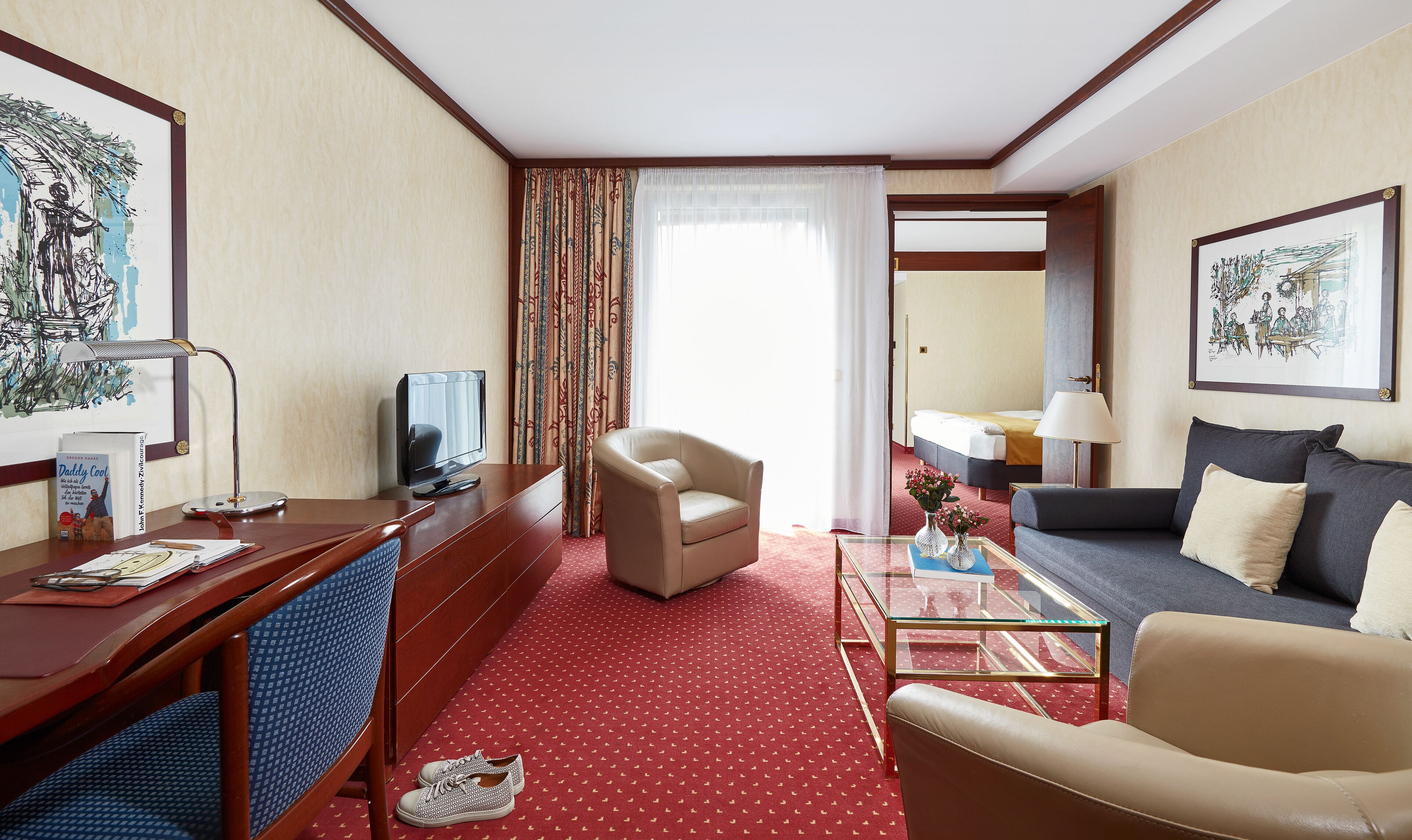 Una habitación de hotel con escritorio, silla, sofá y cama.