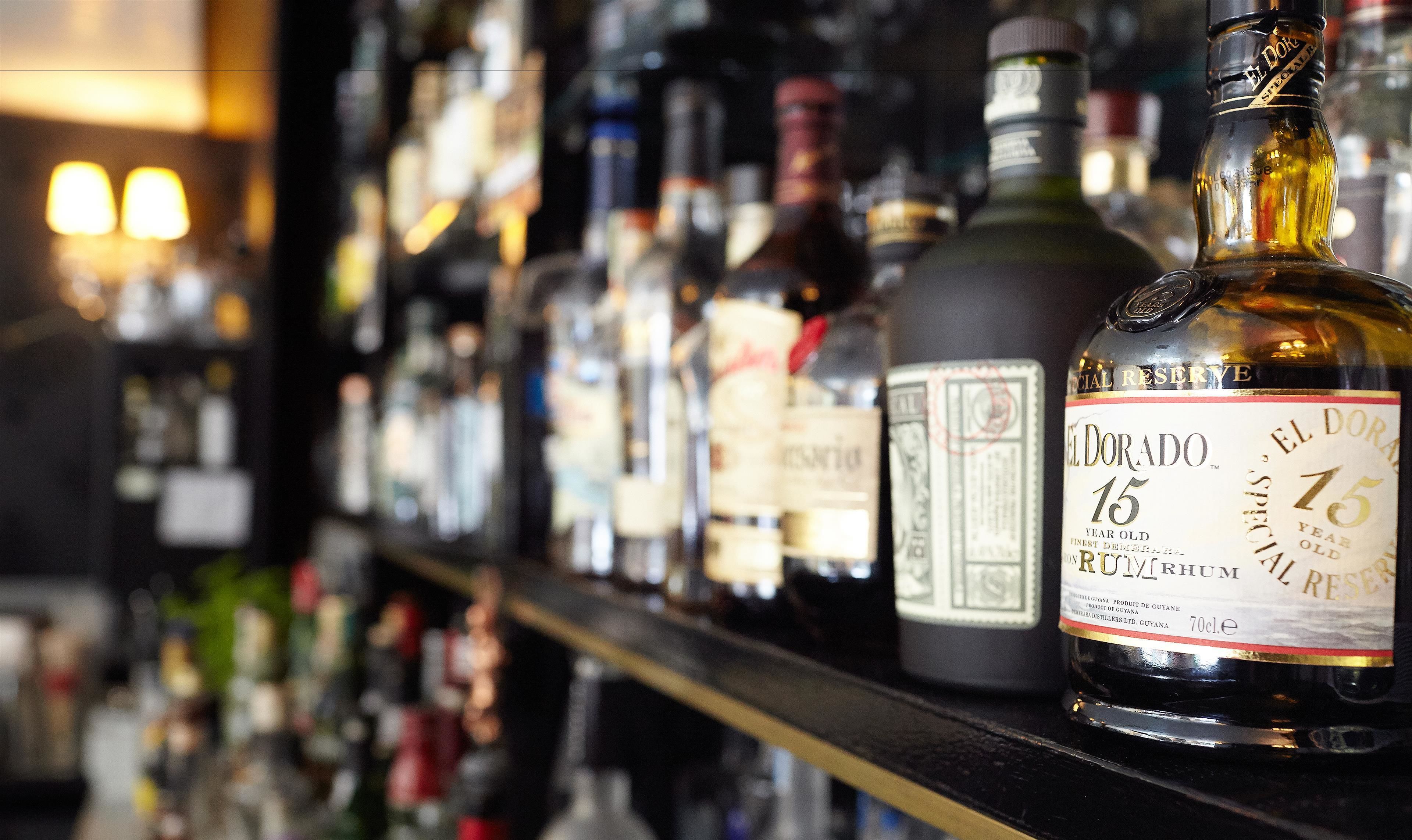 Un bar con varias botellas de alcohol, incluyendo una botella destacada de ron El Dorado.