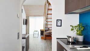 Una cucina moderna con un piano di lavoro in legno, una pianta in vaso e una pentola in acciaio inossidabile.