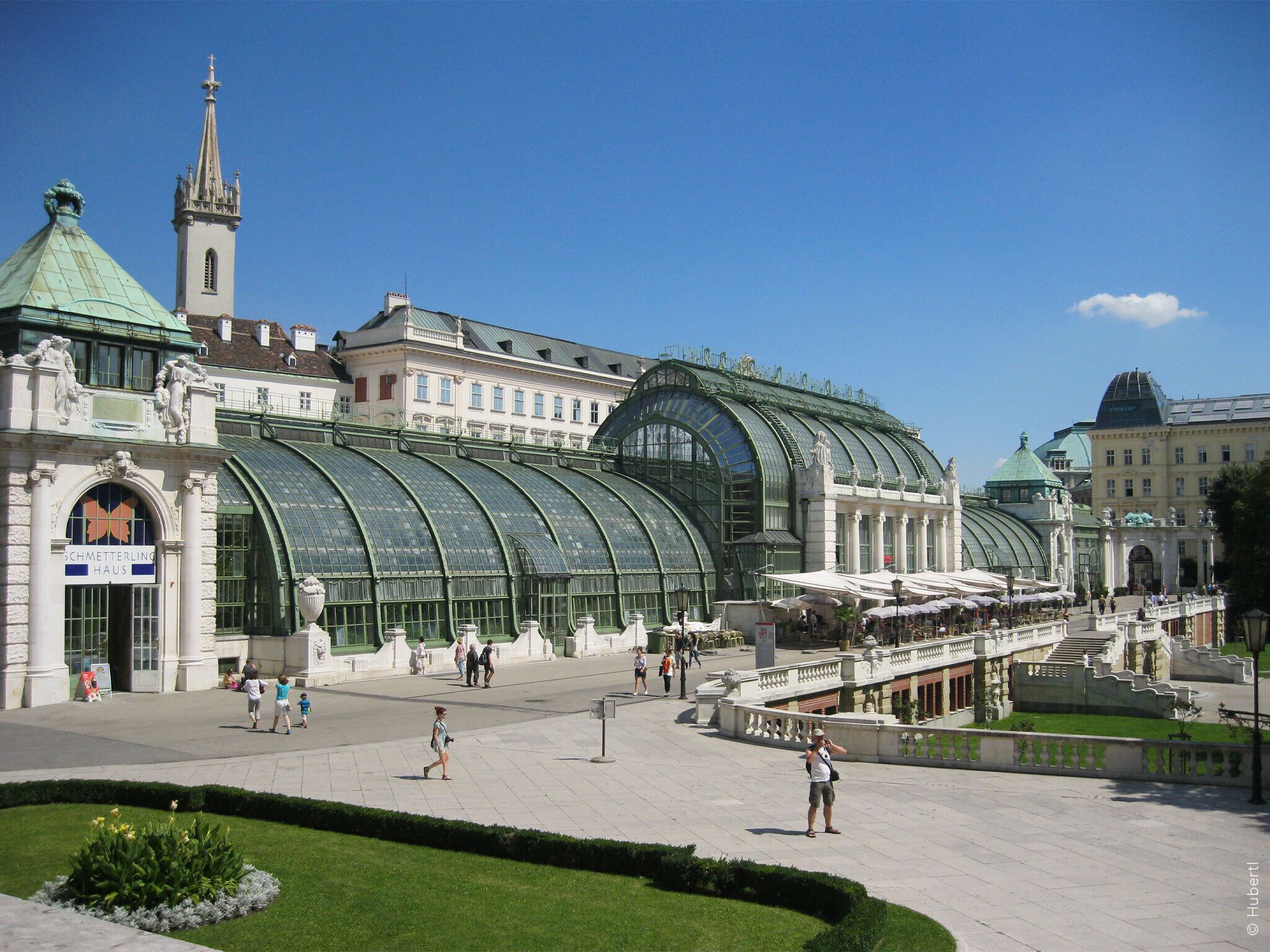 Un edificio grande e histórico con un techo de vidrio verde distintivo y arquitectura clásica.