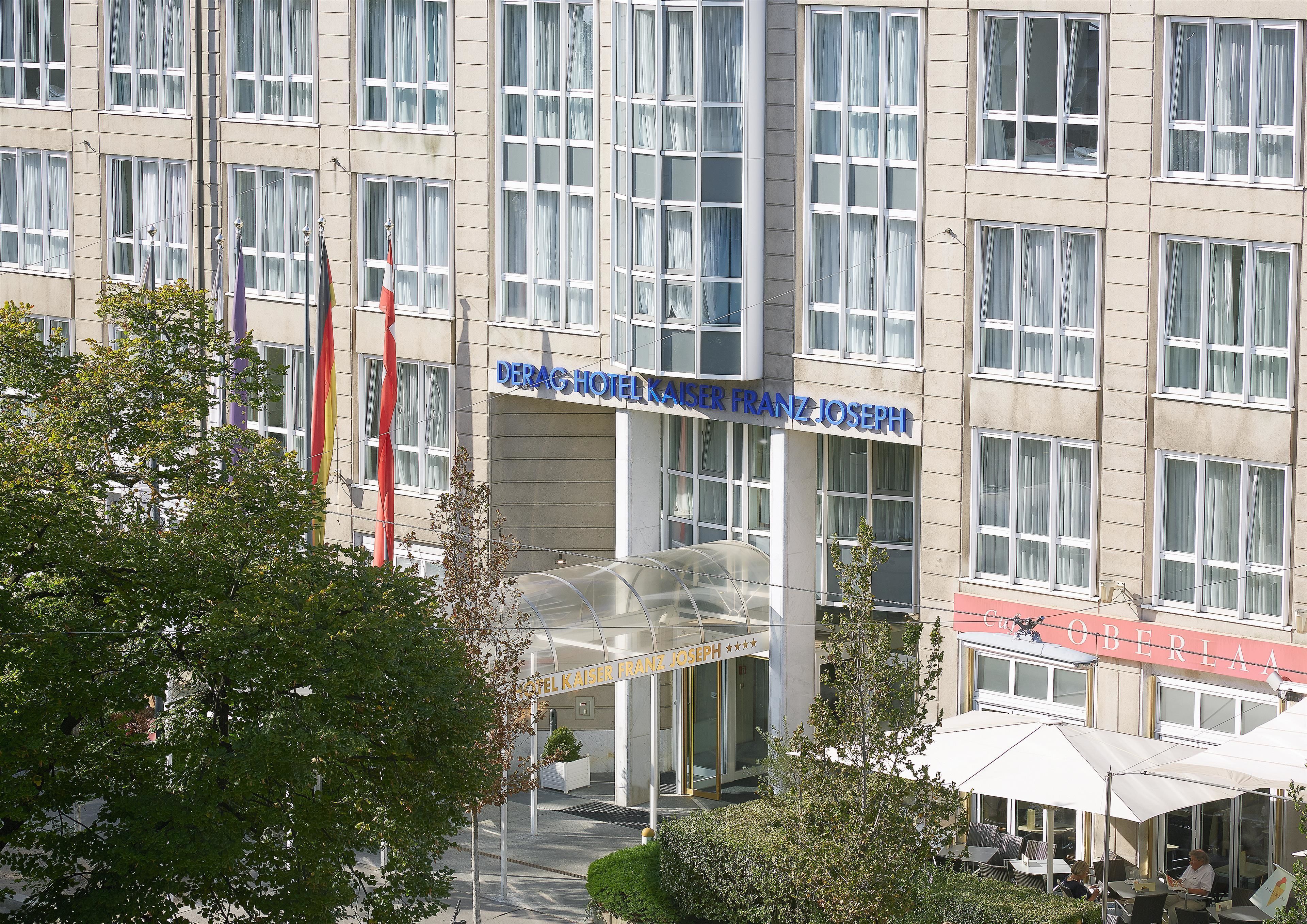 Un bâtiment d’hôtel doté de nombreuses fenêtres, d’une entrée bien visible et d’un espace extérieur aménagé pour s’asseoir.