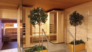 Um interior moderno com paredes de madeira, uma escadaria com grades de vidro e duas plantas em vasos.