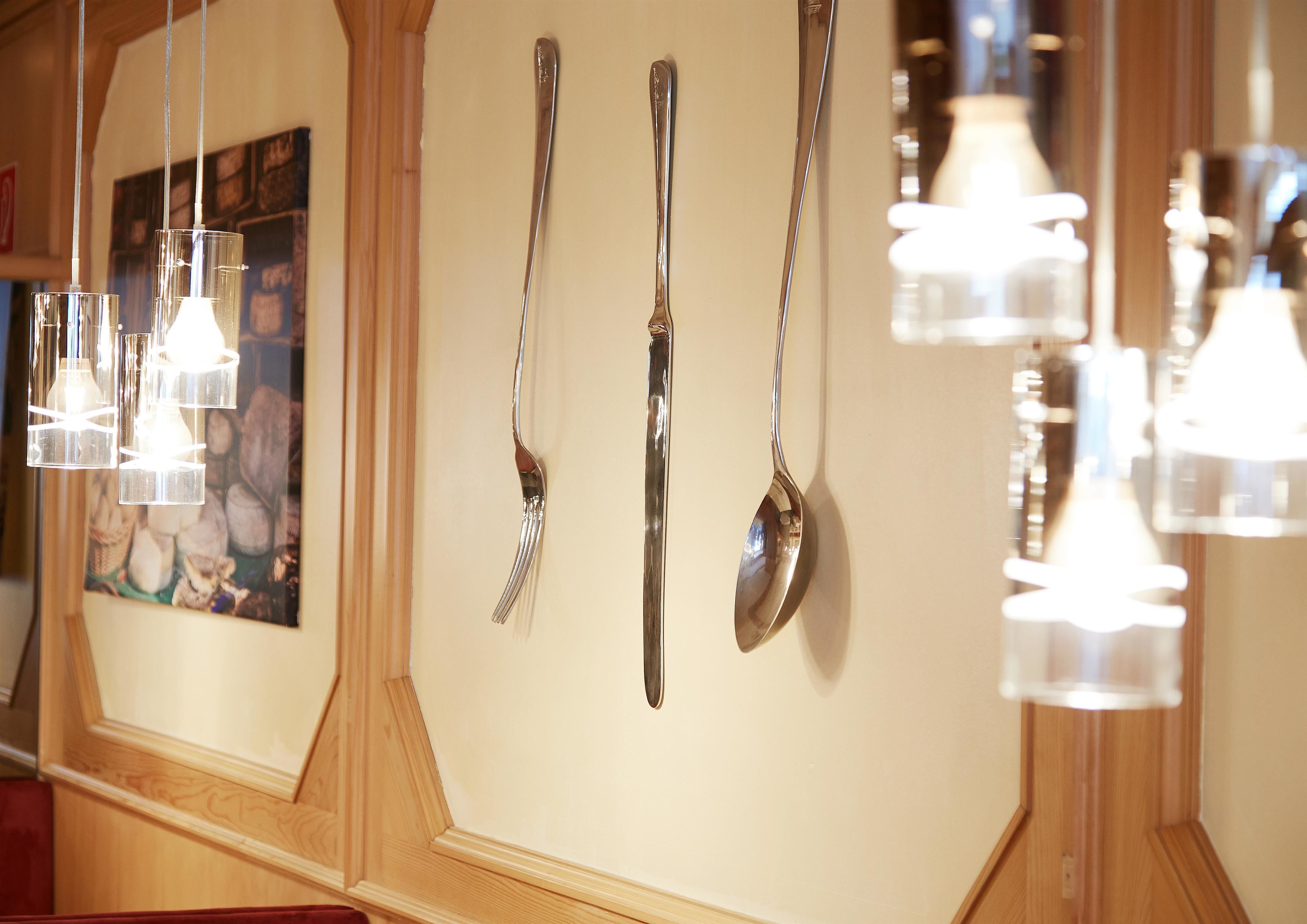 A wall with hanging utensils and pendant lights.