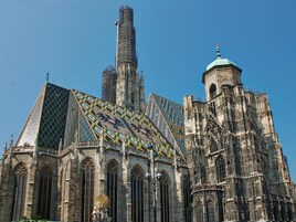 Uma catedral histórica com arquitetura gótica intrincada, com torres altas, detalhes em pedra elaborados e grandes janelas de vitrais.