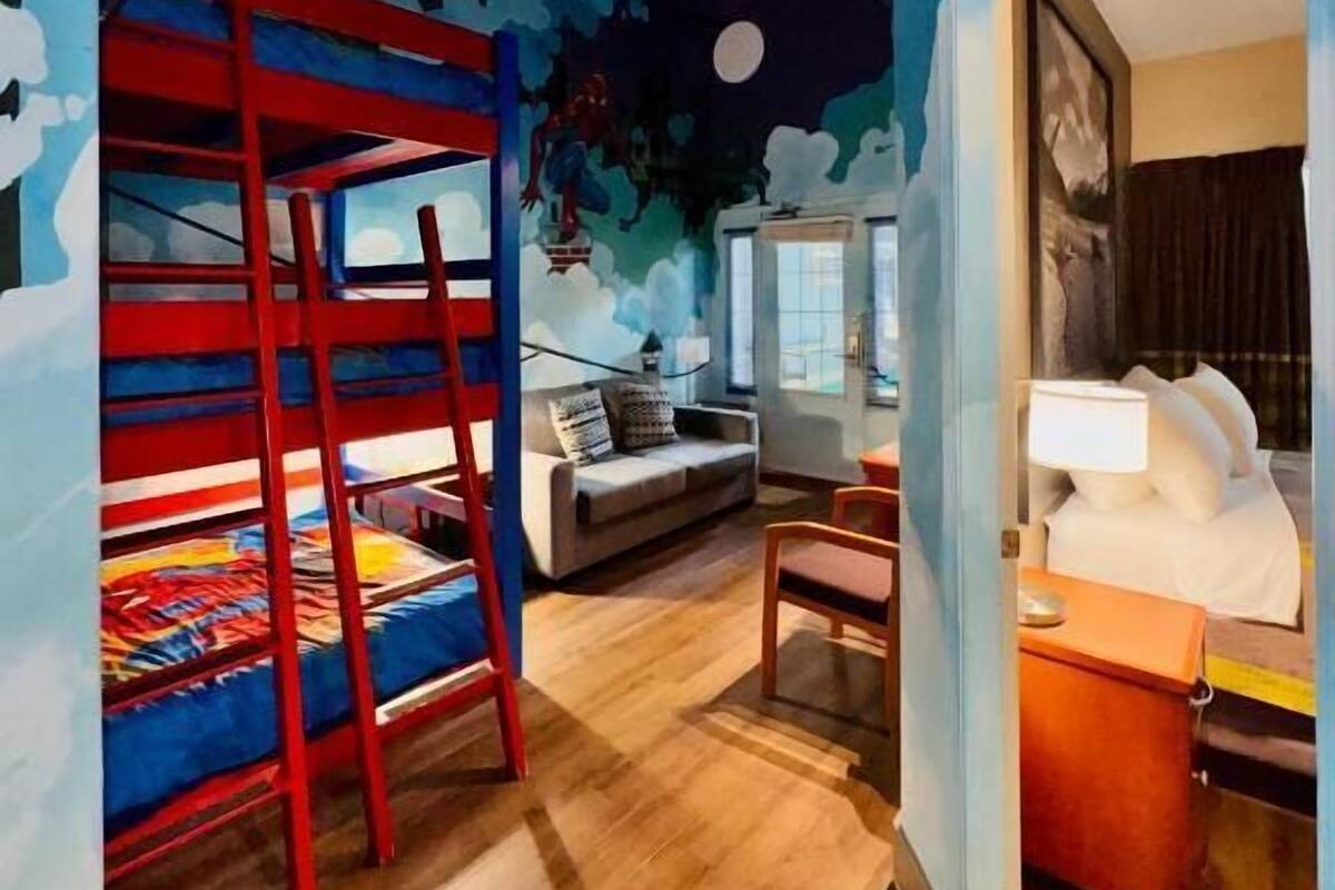 A room with bunk beds, a sofa, a desk, and a bed.