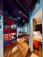 Una habitación con literas, un sofá, un escritorio y una cama.