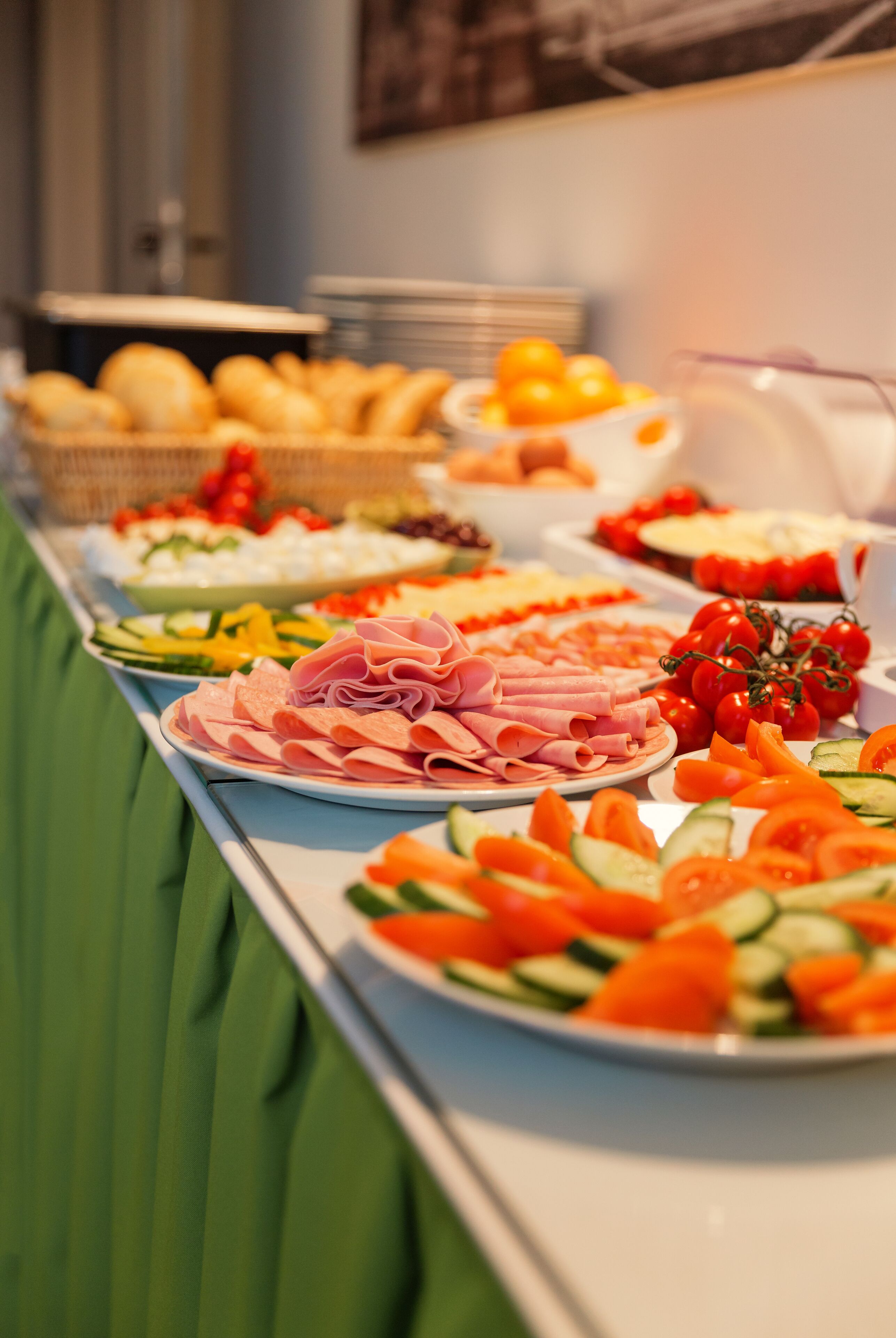 Una mesa de buffet con diversos alimentos, incluyendo carnes, quesos y verduras.