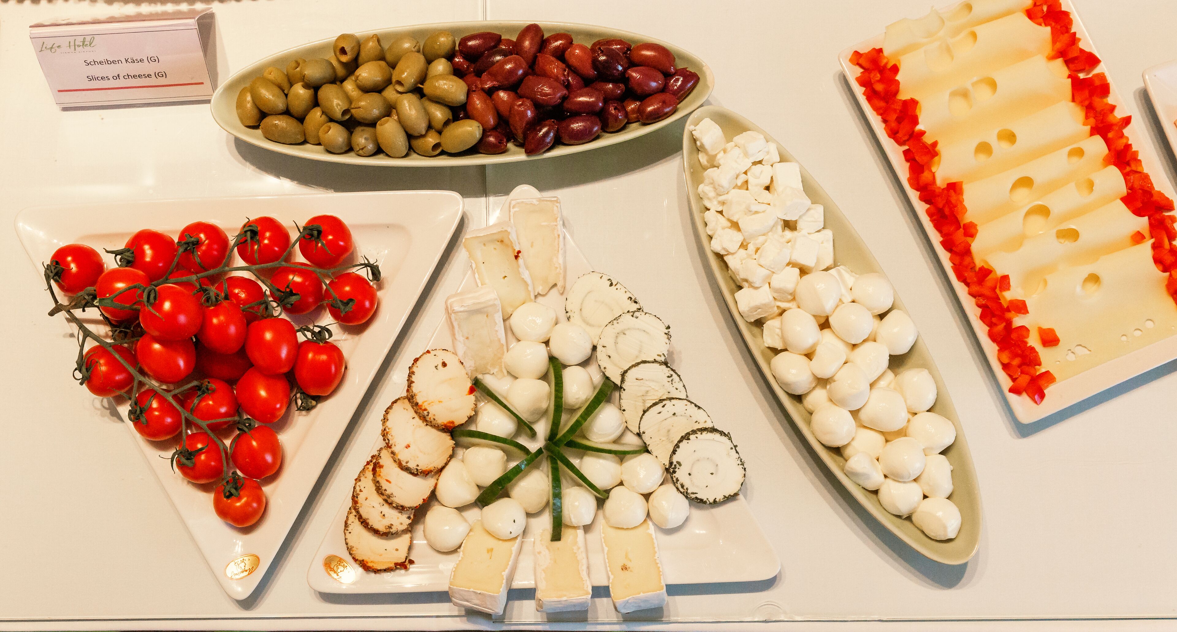 A variety of cheese and olives on a table.