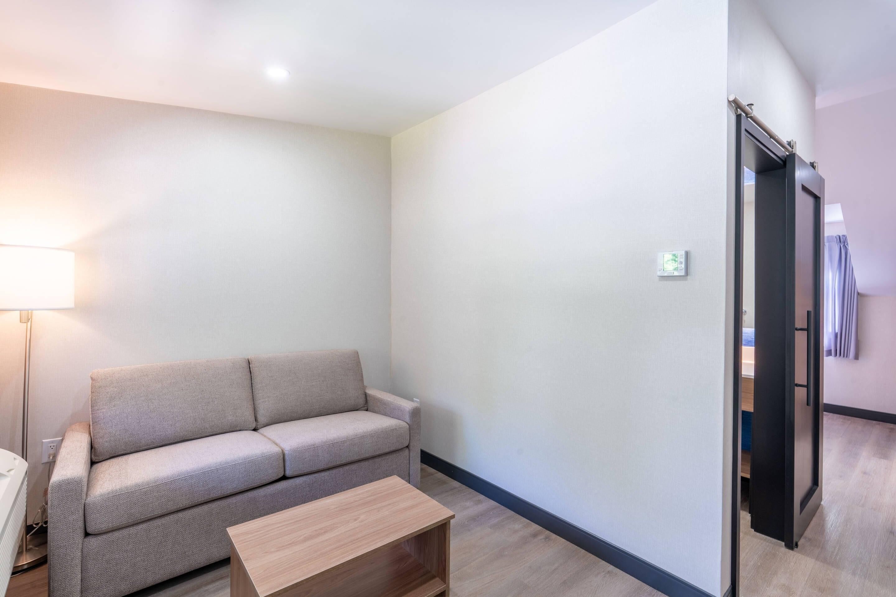 Una sala de estar moderna con un sofá, una mesa de centro y una lámpara.