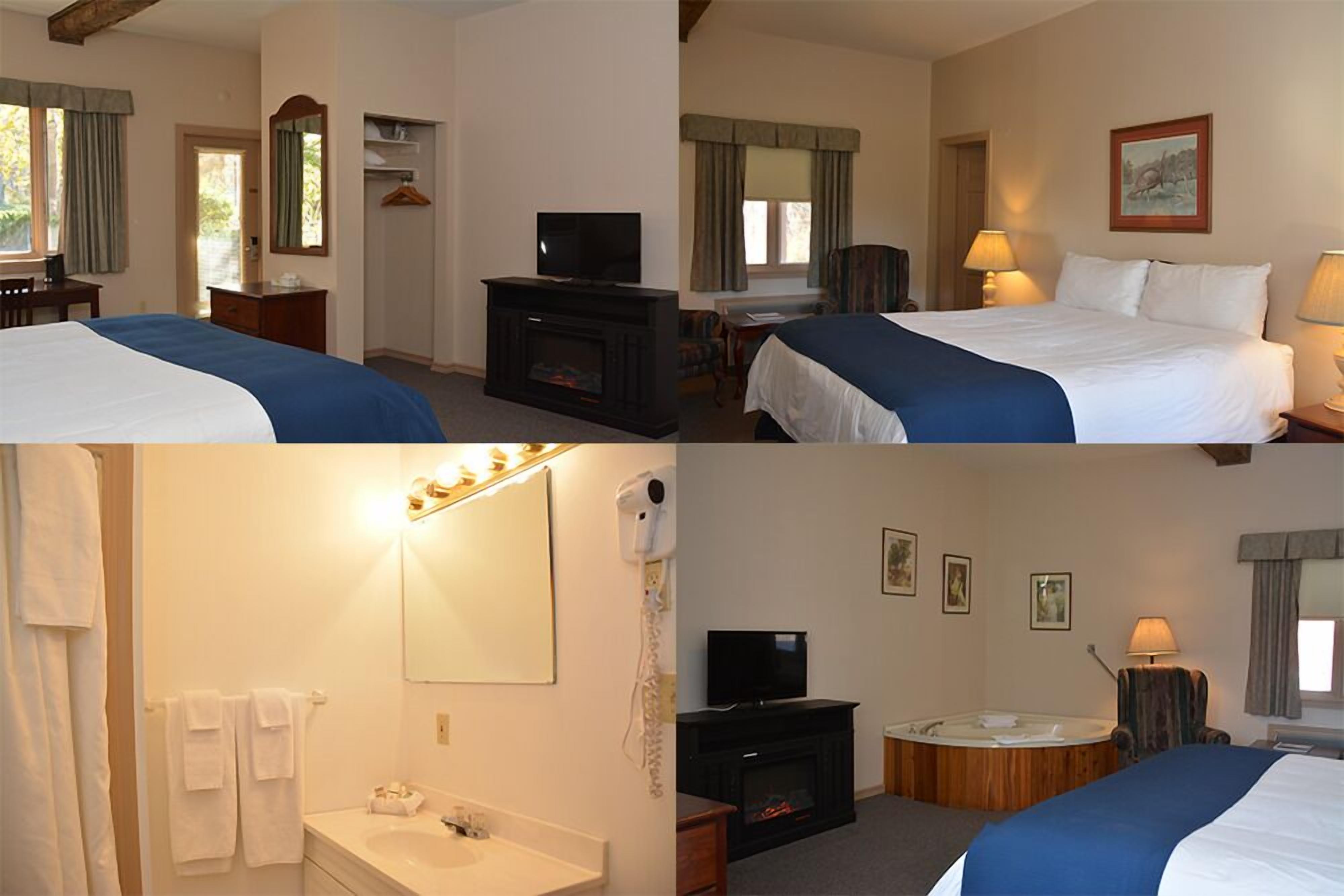 A hotel room with a bed, television, fireplace, and a bathroom with a sink and mirror.