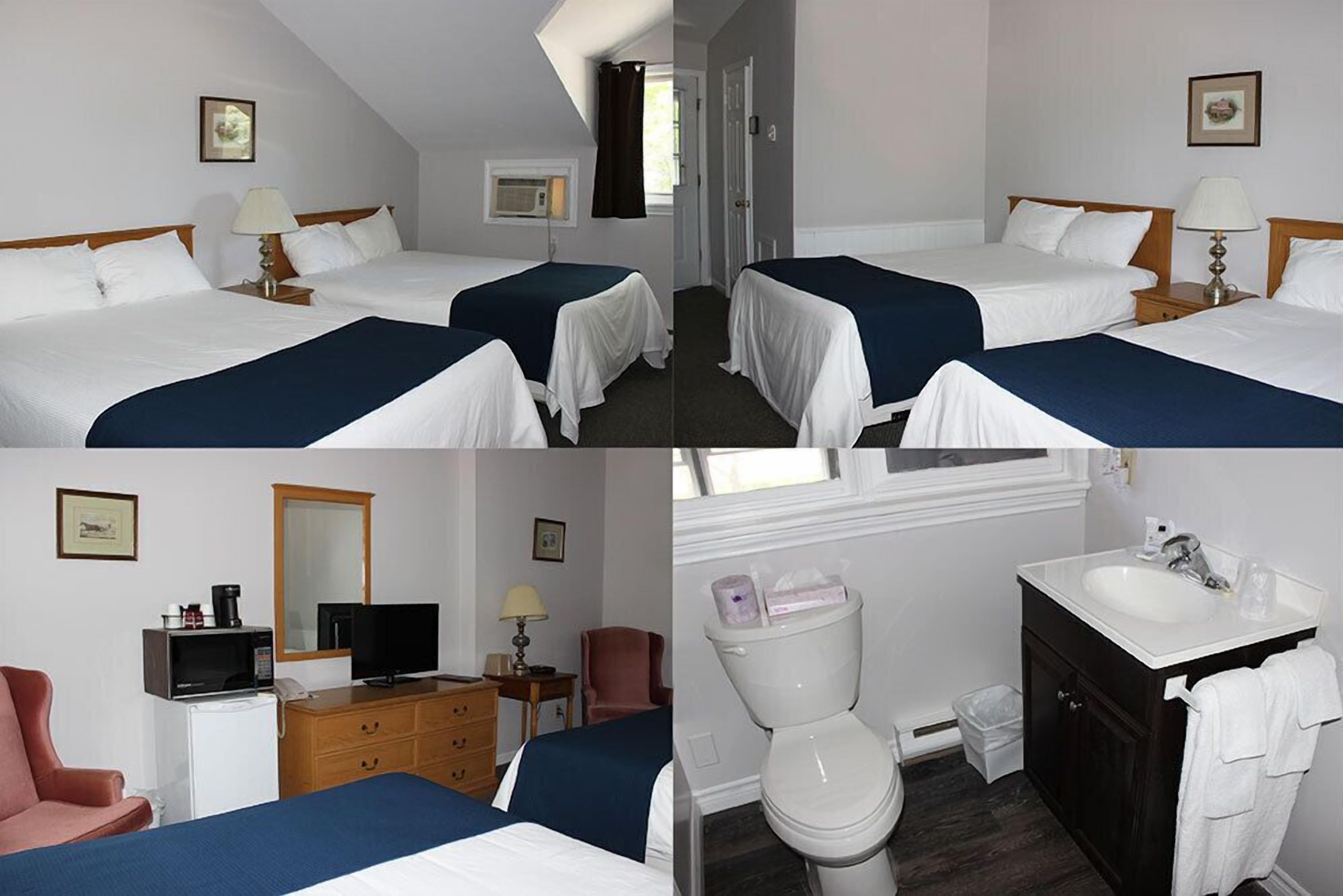 Habitación de hotel con dos camas, un escritorio con computadora, televisor, refrigerador pequeño, una silla y baño con inodoro, lavamanos y espejo.