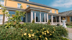 A yellow building with large windows and a white porch. - Sheedy's Country House Hotel (Lisdoonvarna)