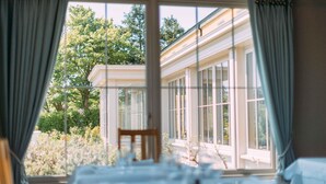 A room with a large window, a table, and a chair. - Sheedy's Country House Hotel (Lisdoonvarna)