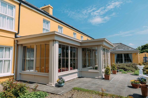 A yellow building with large windows and a covered patio area.