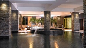 A spacious indoor area with a central water feature, stone pillars, and seating areas. - Bayview Hotel (Ballycotton)
