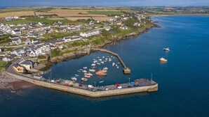 An aerial view of a coastal town with a harbor, boats, and houses. - Bayview Hotel (Ballycotton)