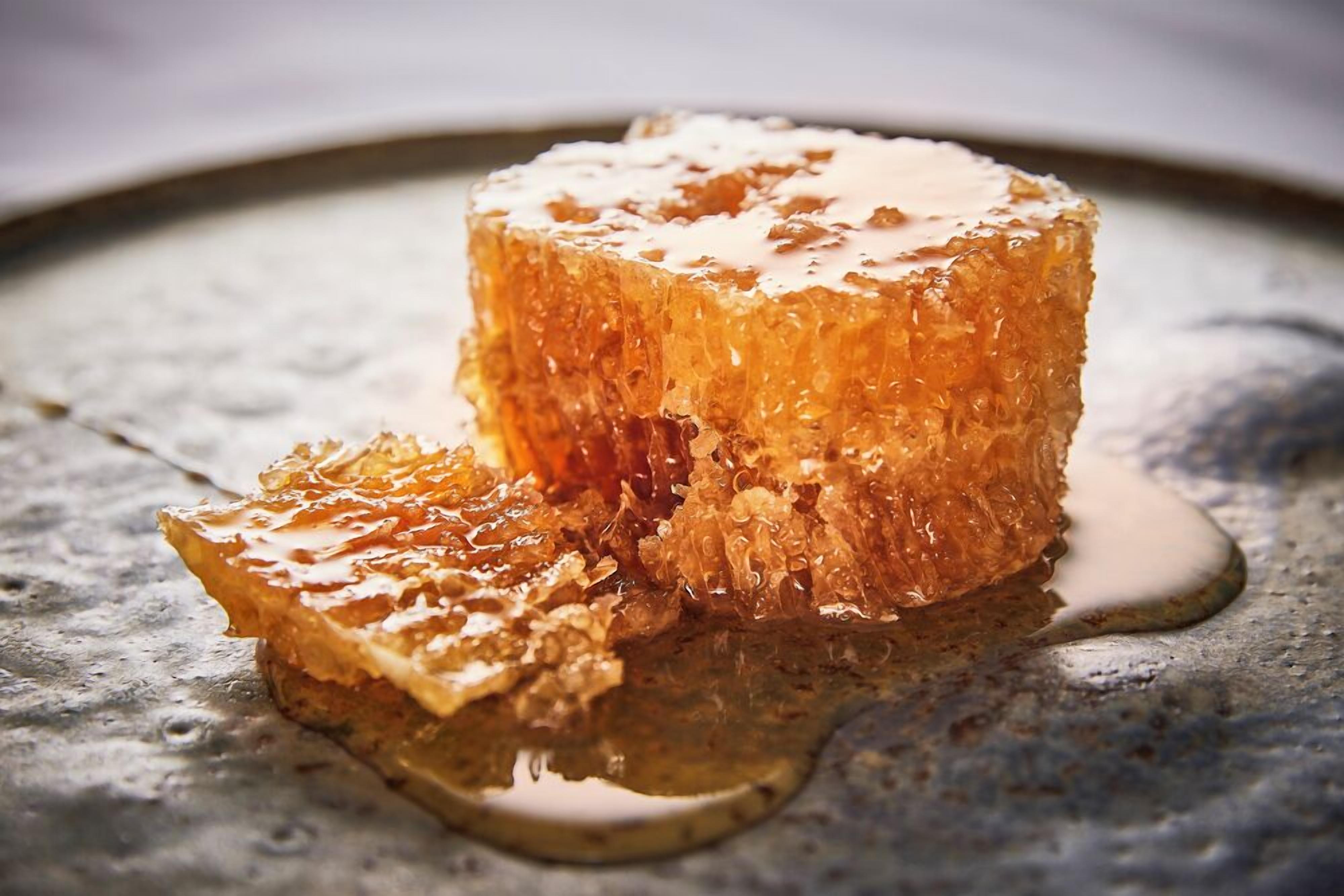 Un postre de panal en un plato, con un líquido escurriendo.