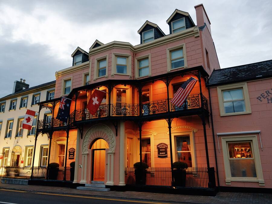 A pink building with a sign that reads "Perryville House Guest."