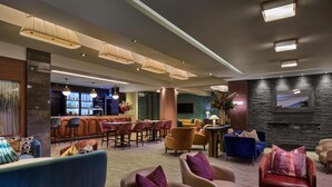 A lobby with seating areas, a reception desk, and a bar. - DoubleTree by Hilton London West End (London)