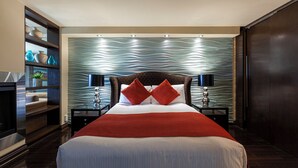 Una habitación de hotel moderna con una cama grande, dos mesitas de noche, un cabecero de madera y un adorno en la pared.
