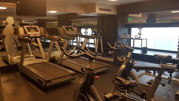 A gym with treadmills, stationary bikes, and a rowing machine.