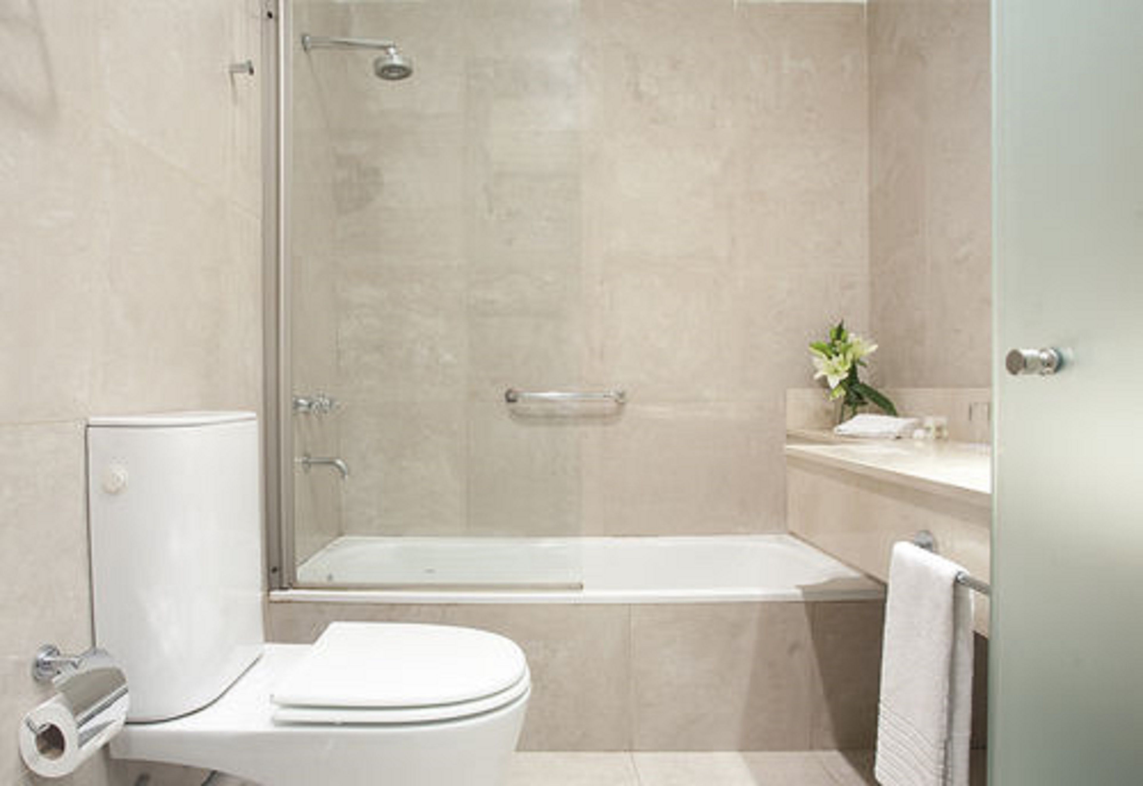 A modern bathroom with a toilet, shower, and bathtub.