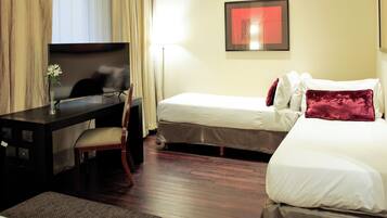 Una habitación de hotel con una cama, un escritorio y una silla.