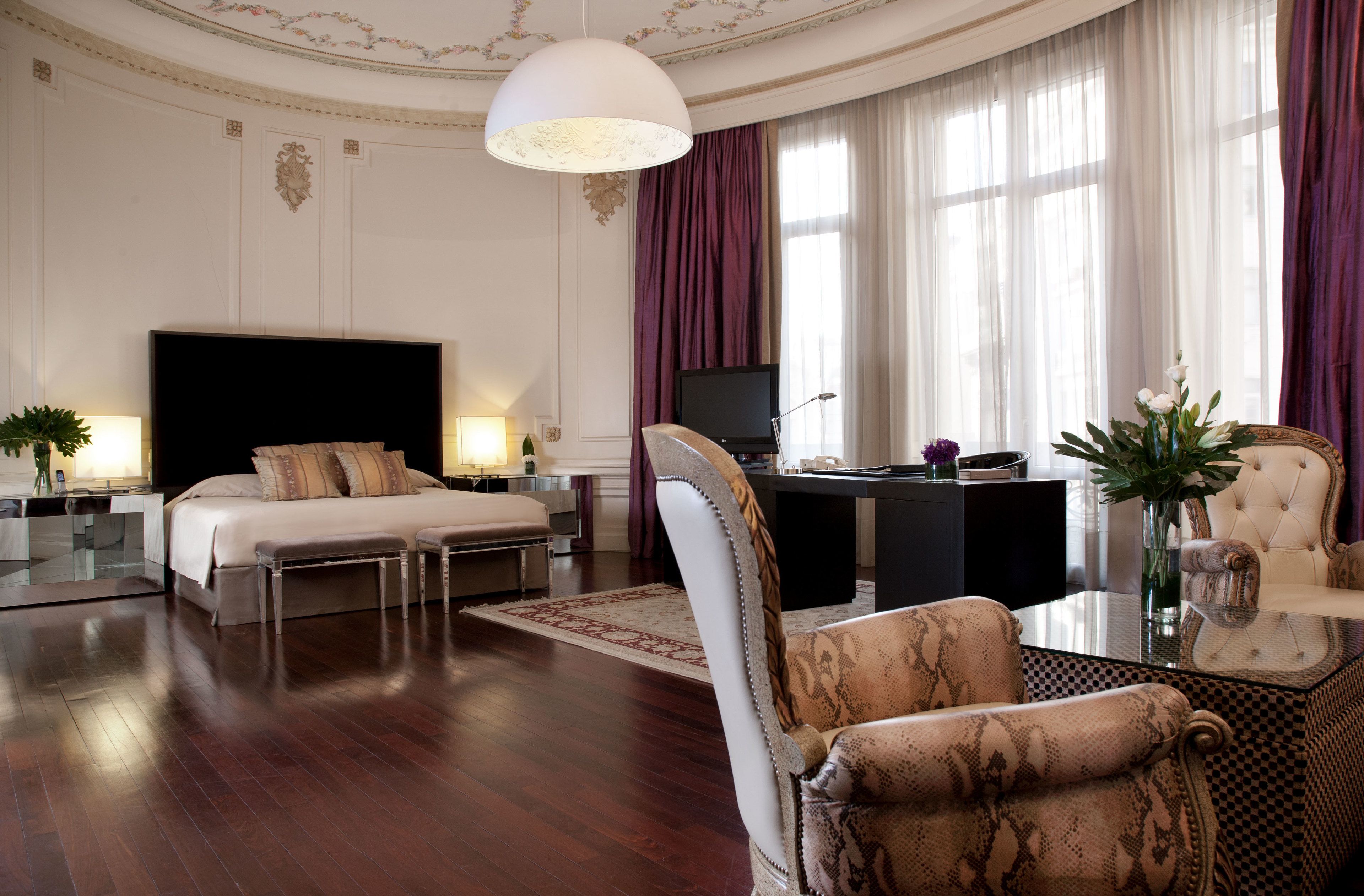 Une chambre d’hôtel spacieuse, dotée d’un grand lit, d’un bureau, d’une chaise et d’un téléviseur.
