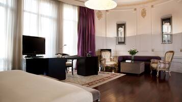 Une chambre d’hôtel équipée d’un lit, d’un bureau, d’une télévision, d’un canapé et d’une chaise.
