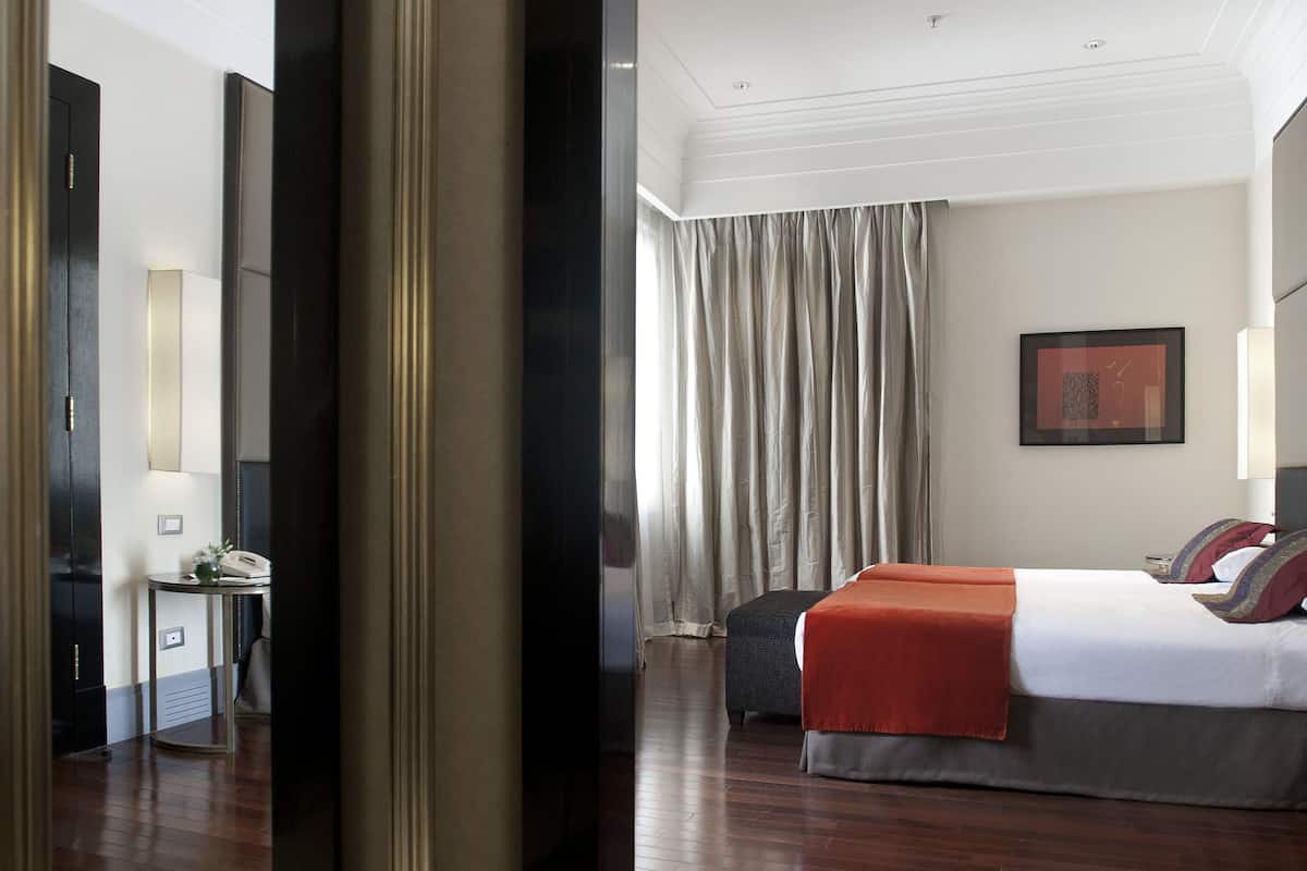 Una habitación de hotel moderna con una cama grande, un escritorio y un espejo.