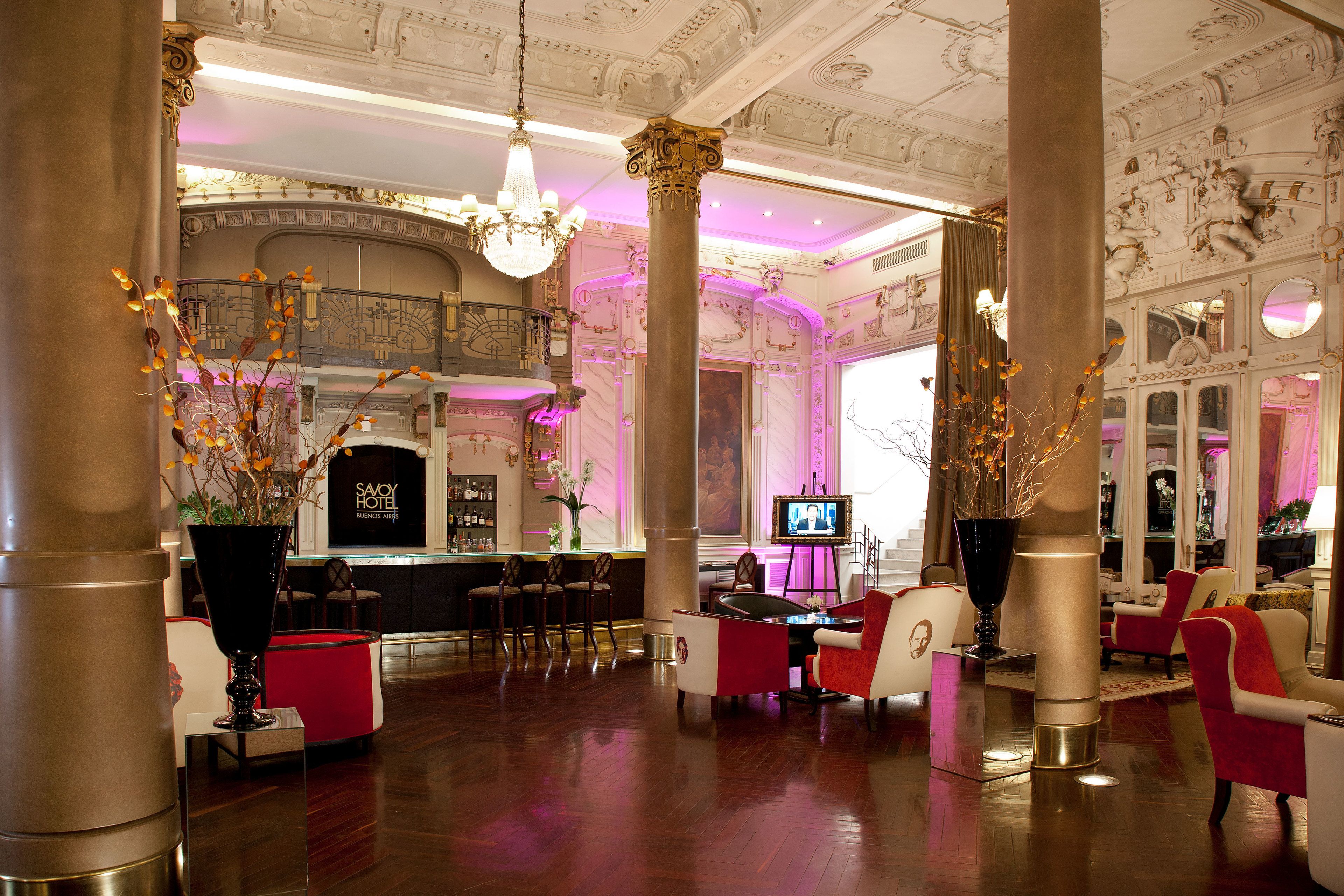 A luxurious lobby with ornate columns, a bar area, and seating arrangements.