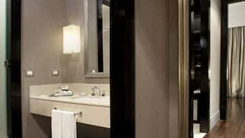 A modern bathroom with a large mirror, a sink, and a towel rack.
