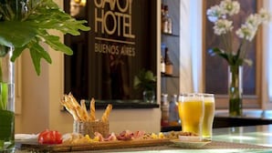 A breakfast setting with a variety of foods and drinks, a sign for 'Savoy Hotel Buenos Aires', and a view of the interior. - Savoy Hotel (Buenos Aires)