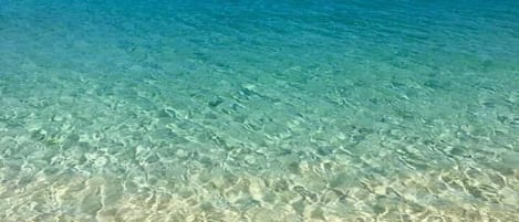 On the beach, white sand, sun-loungers, beach towels