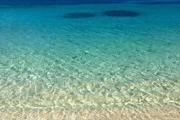 En la playa, arena blanca, sillas reclinables de playa, toallas de playa