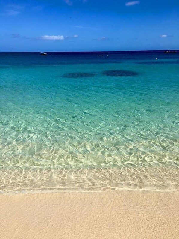 On the beach, white sand, sun loungers, beach towels