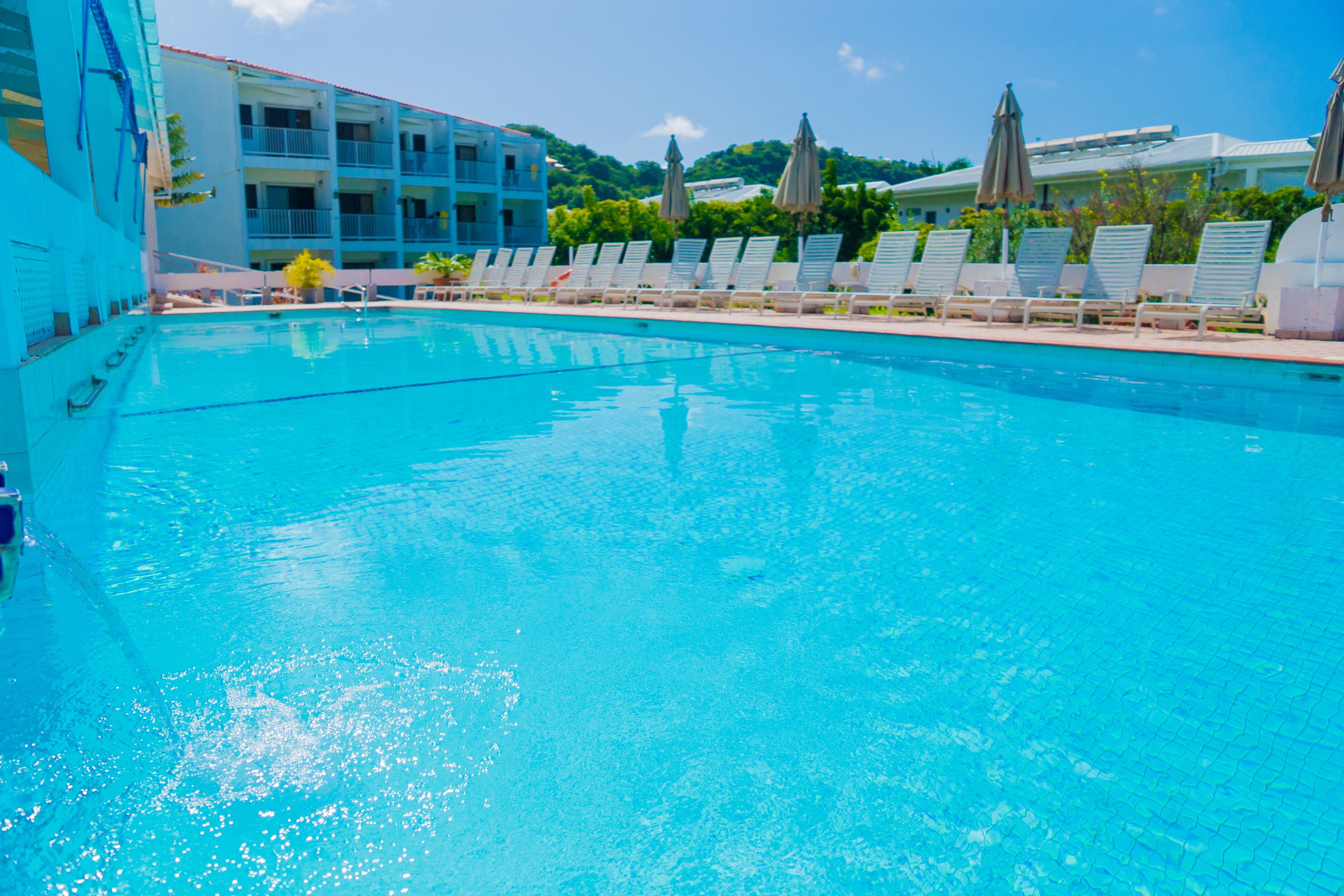 Alberca al aire libre, sombrillas en la alberca y camastros 