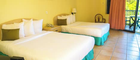Une chambre d’hôtel avec deux lits, un bureau, un téléphone et une fenêtre avec un rideau.