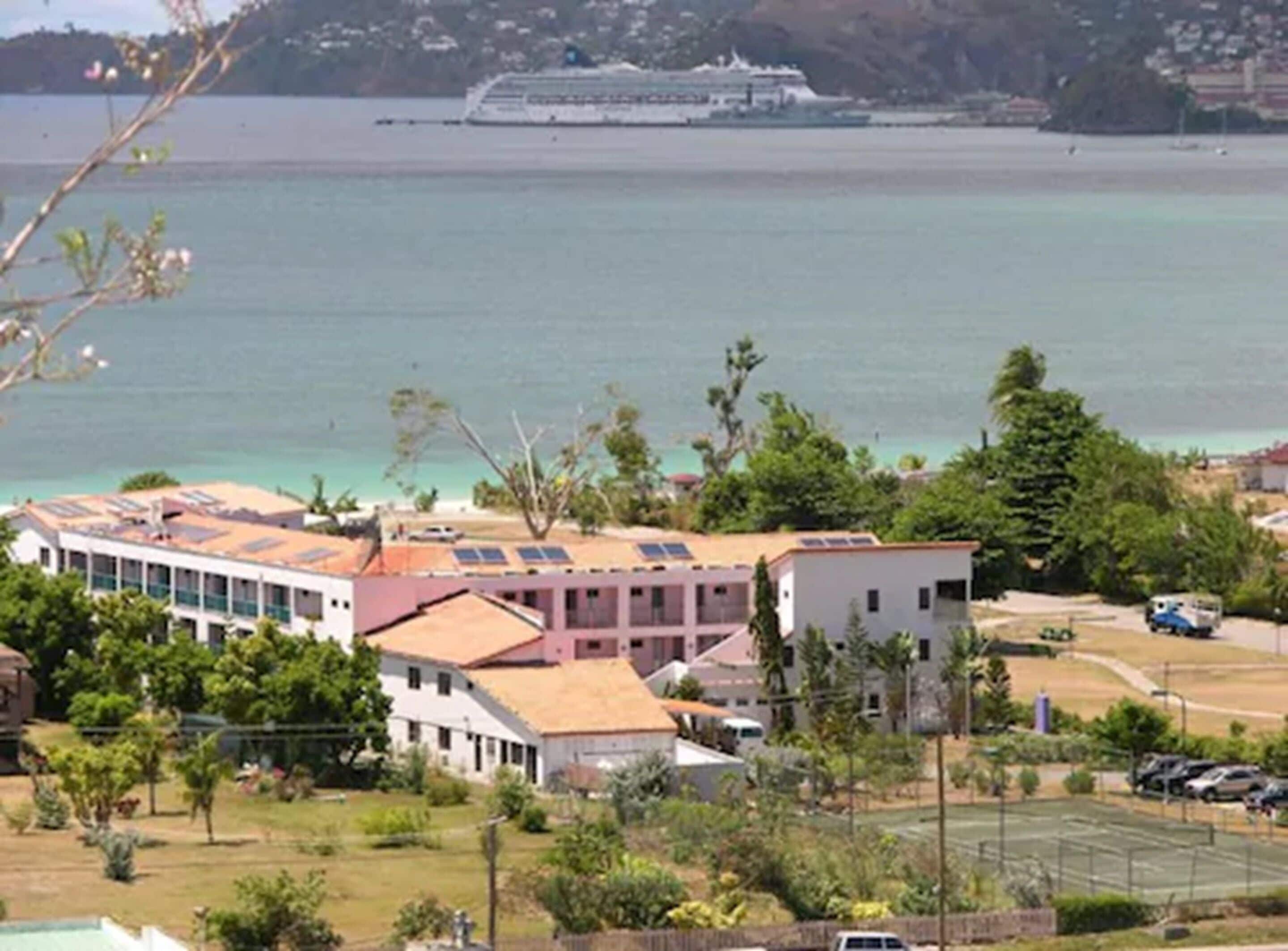 Un hôtel situé sur la côte, composé de plusieurs bâtiments, doté d’un parking et offrant une vue sur la mer.