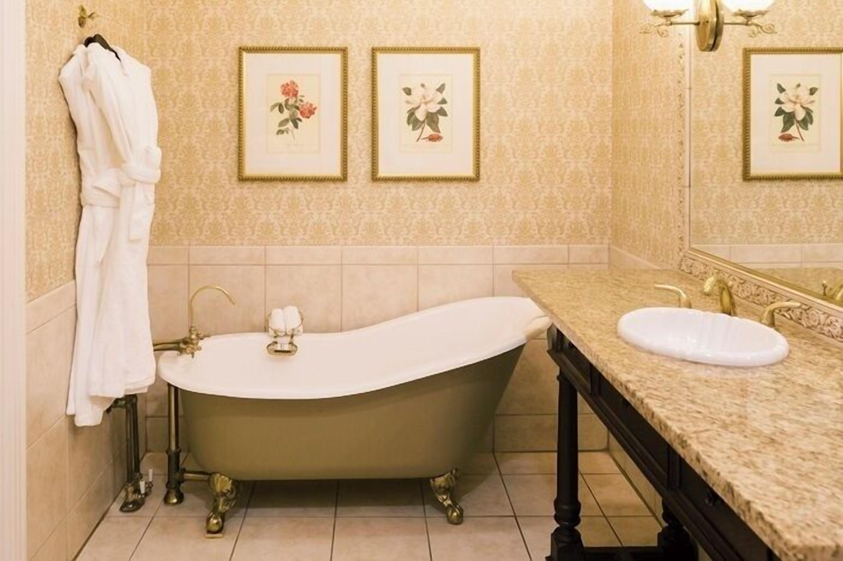 A bathroom with a freestanding bathtub, a sink, and a towel rack.