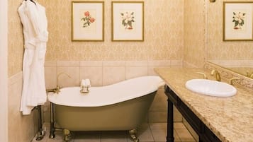 A bathroom with a freestanding bathtub, a sink, and a towel rack.