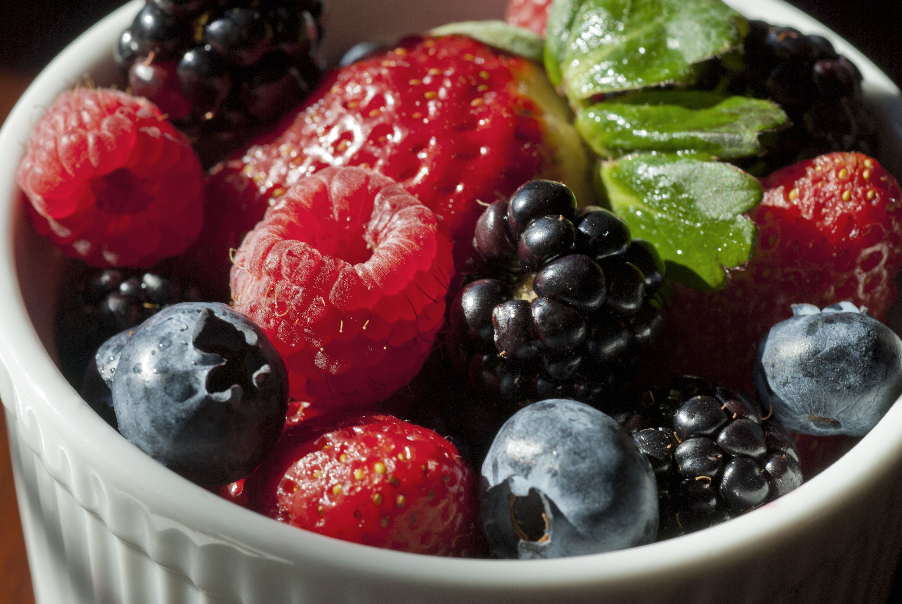 A bowl of mixed berries including raspberries, blackberries, and blueberries.