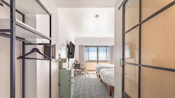 A modern hotel room with a bed, a desk, a television, and a wardrobe. - Hotel Koxie (Los Angeles)