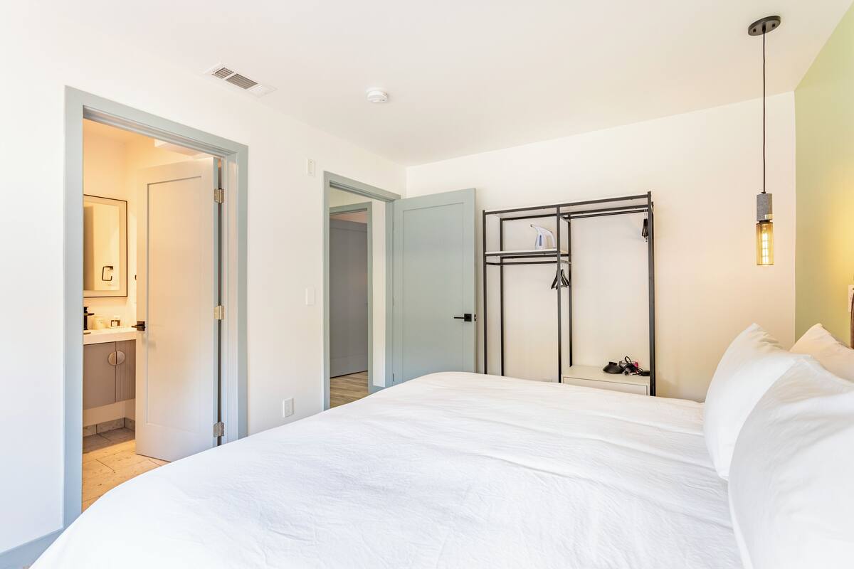 A bedroom with a large bed, a wardrobe, and a mirror.